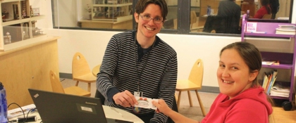 Photo of Loussac staff handing library card to patron