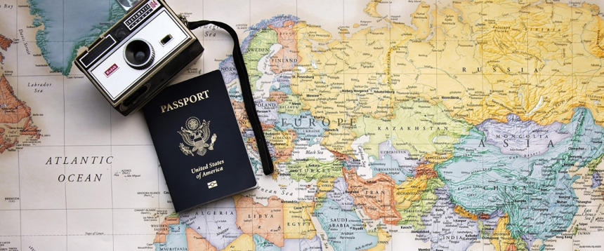 Camera and US passport on top of world map