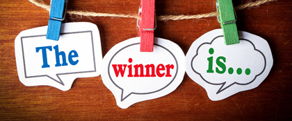 Tags hanging by clothespins on a wood background with the text "The winner is..."