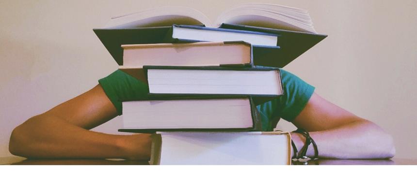 Person sitting behind stack of books