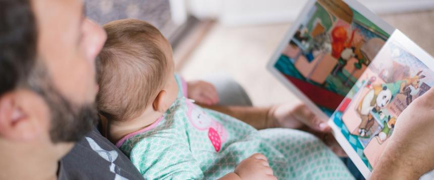 Photo of man reading to baby
