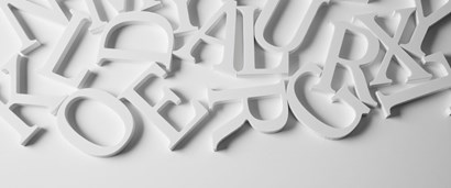 Large white cut outs of various letters of the alphabet scattered across a white background.
